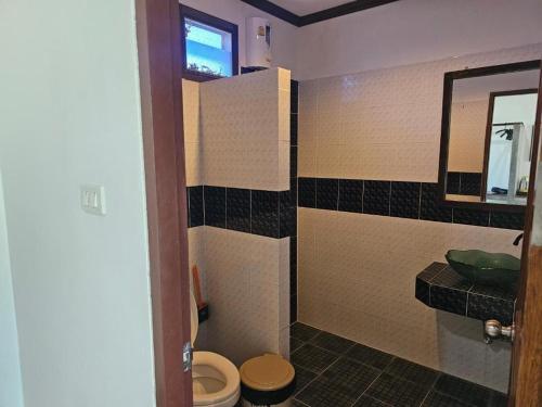 a bathroom with a toilet and a sink at Cha-Tinnie Hotel in Phra Ae beach