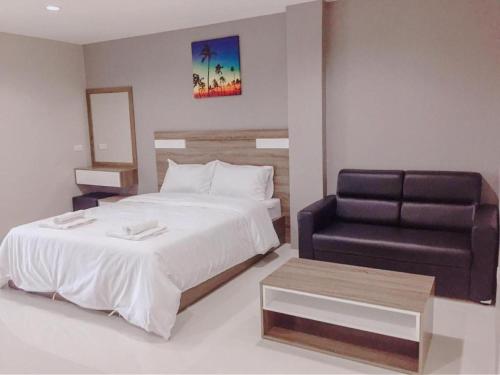 a bedroom with a bed and a black chair at PJ PLACE in Ban Bang Samak