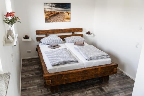 a bedroom with a wooden bed with white sheets at Lebensfreude in Goch