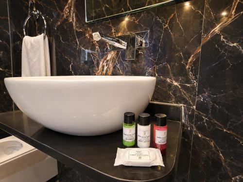 a bathroom with a white bowl and a sink at HOTEL NEAR KASHI VISHWANATH VARANASI SHREE R-KRISHNA - wifi - Lift - FAMILY HOTEL in Varanasi