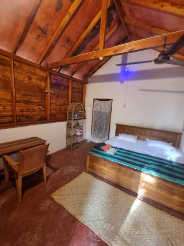 a bedroom with a bed and a desk in a room at River Point in Pottuvil