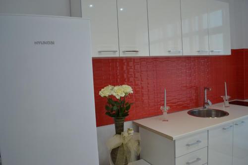 a kitchen with a sink and a vase of flowers at City Park Residence in Constanţa