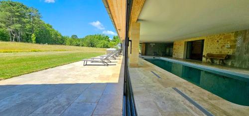 a house with a swimming pool next to a field at PETIT PARADIS 24 in Groléjac