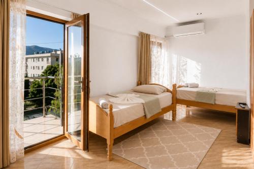 a bedroom with two beds and a balcony at Bar Hotel Tirana in Kukës
