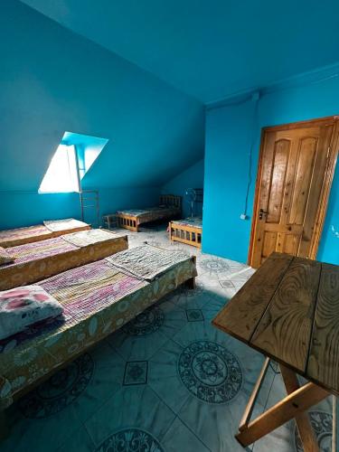 a blue room with two beds and a wooden door at Ararat in Ozurgetʼi