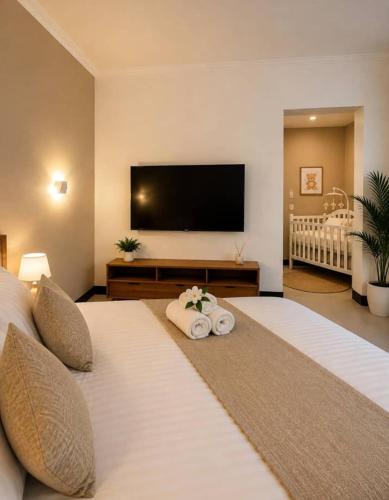 a bedroom with two beds and a flat screen tv at The Serenity Hideaway in Arusha