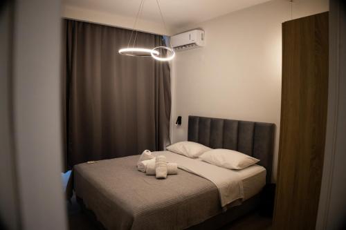 a bedroom with a bed with two white towels on it at Kalma Apartment Xanthi Center in Xanthi