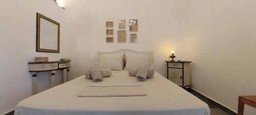 a bedroom with a large white bed with a candle at Margaritari Sifnos in Platis Gialos