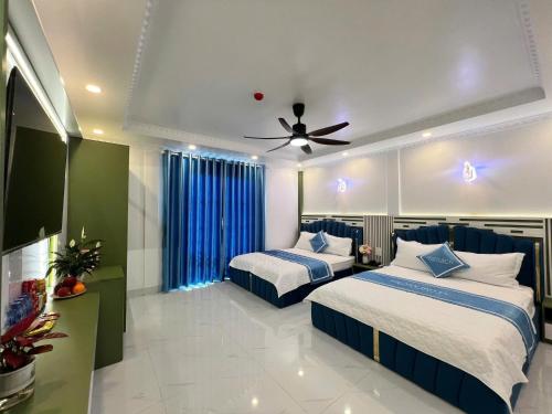 a bedroom with two beds and a ceiling fan at Legacy Hotel in Kỳ Vĩ