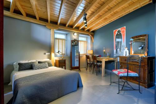 a bedroom with a bed and a table and chairs at eliamaria artistic house in Lefkada