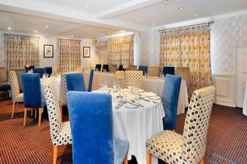 a conference room with a long table and blue chairs at Ardington Hotel in Worthing
