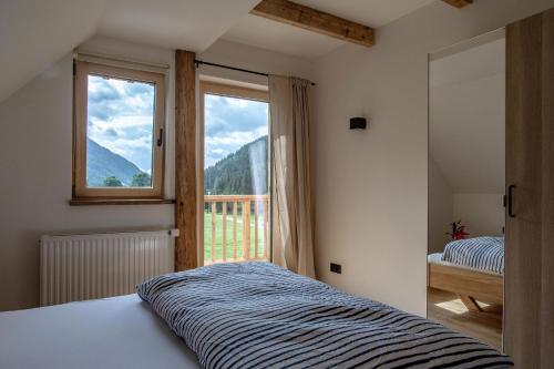a bedroom with a bed and a large window at Das Detox Almhaus in Pusterwald