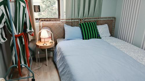 a small bedroom with a bed with blue and green pillows at Daol in Seoul