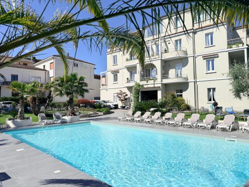a swimming pool in front of a building at Hotel Benaco in Desenzano del Garda