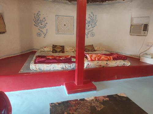 a room with two beds on a red platform at Aalamaram Farm in Anchetti