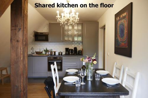 a kitchen with a black table with chairs and a chandelier at Schloss Mörlbach in Icking