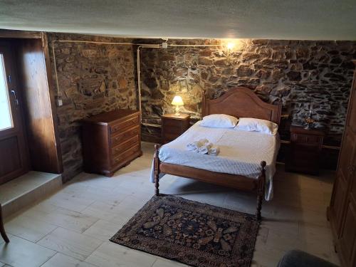 a bedroom with a bed in a room with stone walls at Casinha Meixedo in Bragança