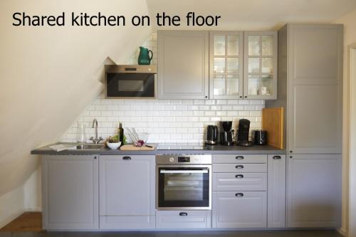 a kitchen with white cabinets and a stove at Schloss Mörlbach in Icking