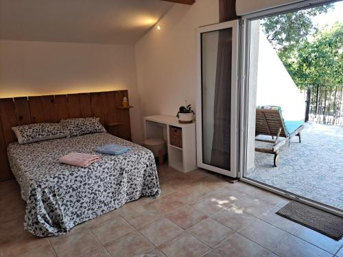 a bedroom with a bed and a sliding glass door at BEAU STUDIO NEUF en provence in Pélissanne