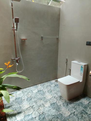 a bathroom with a toilet and a shower at Mukalawatta Villa in Matara