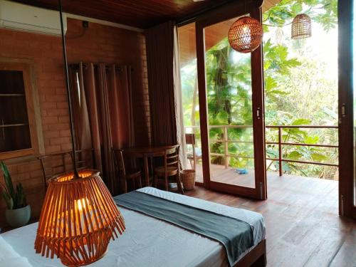 a bedroom with a bed with a lamp and a balcony at Mukalawatta Villa in Matara