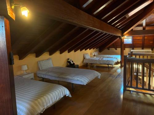 two beds in a room with wooden ceilings at Balentzenea Rural House in Lesaka