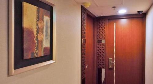ein Badezimmer mit einem Gemälde an der Wand neben einer Tür in der Unterkunft Oriental Lander Hotel in Hongkong