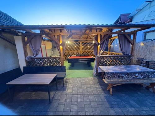 a patio with two benches and a table at Sixtor hause in Salonta