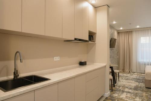 a kitchen with white cabinets and a sink at Solara in Bishkek