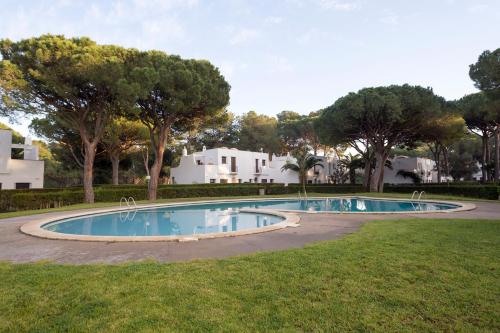 una piscina en un patio con árboles y casas en Casas en Piverd del Golf, en Pals