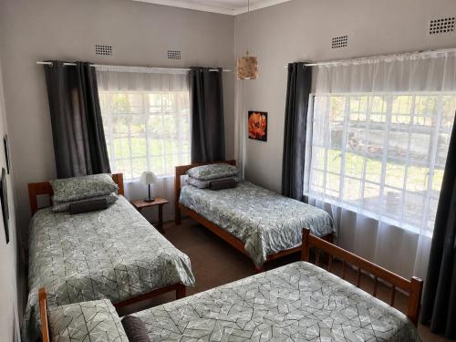 a bedroom with two beds and a window at Nut Tree Nook in Hazyview