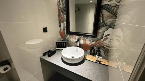 a bathroom with a sink and a mirror at KL International Hotel in Kuala Lumpur