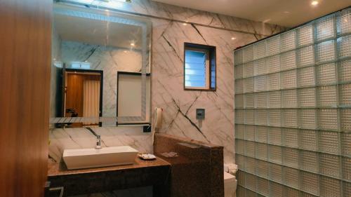 a bathroom with a sink and a mirror at Hotel Mulki International in Mūlki