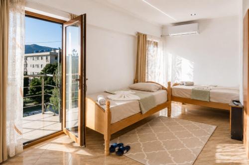 a bedroom with two beds and a large window at Bar Hotel Tirana in Kukës