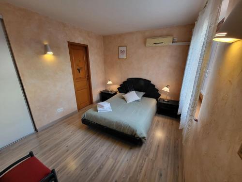 a bedroom with a bed and two tables and two lamps at Vignoble in Bennwihr