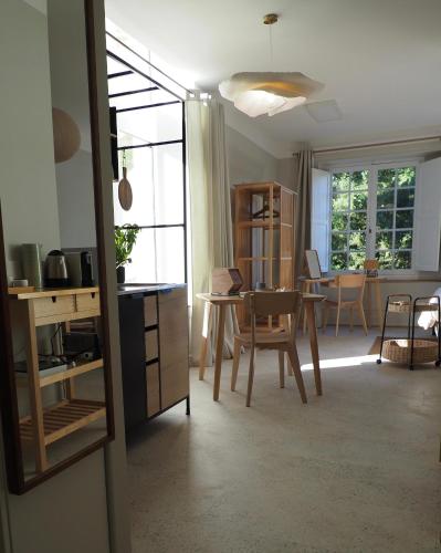 a kitchen and dining room with a table and chairs at APPART en THÈSE Appartement climatisé Accessible PMR Proche Dijon et CEA Valduc in Moloy