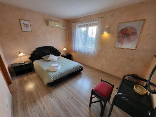 a bedroom with a bed and a table and a chair at Vignoble in Bennwihr