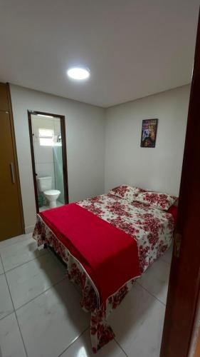 a bedroom with a bed with a red blanket at Pousada Horizontes de Bonito Apto in Bonito