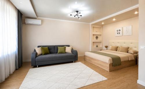 a bedroom with a bed and a couch at Габдуллина 79 in Kokshetau