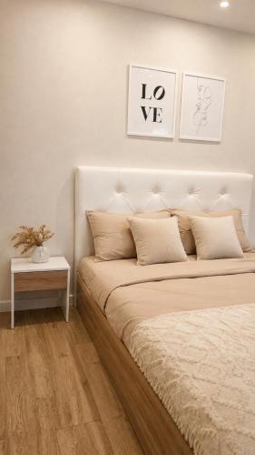 a white bedroom with a large bed and a table at Габдуллина 79 in Kokshetau