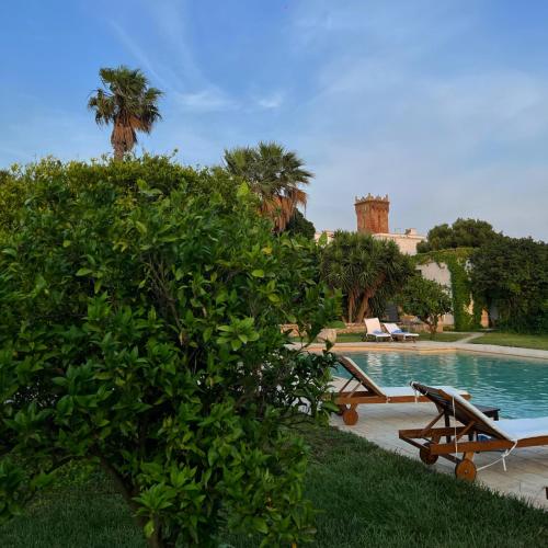 a pool with a table and a bench next to a tree at Masseria Incantalupi in San Vito dei Normanni