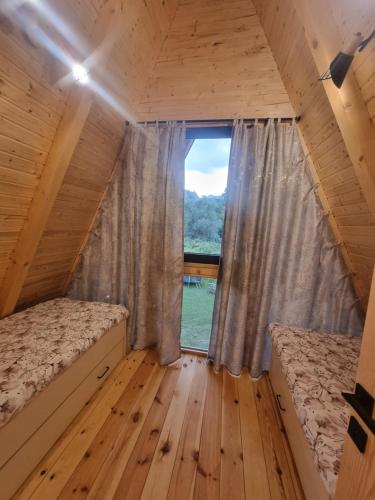 a small room with two beds and a window at durmitor's golden peace in Šavnik