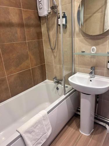 a bathroom with a sink and a bath tub with a sink at Stopover Stoford in Stoford
