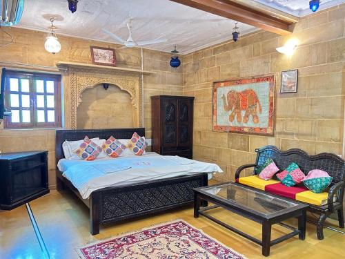a bedroom with a bed and a couch and a table at Hotel Pol Haveli Jaisalmer in Jaisalmer