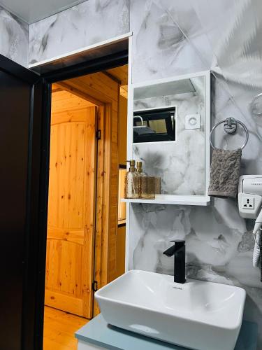 a white bathroom with a sink and a mirror at Gerlik Cottage in Mestia