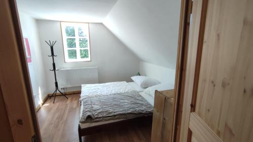 a small bedroom with a bed in a attic at Roubenka in Nieder Kreibitz