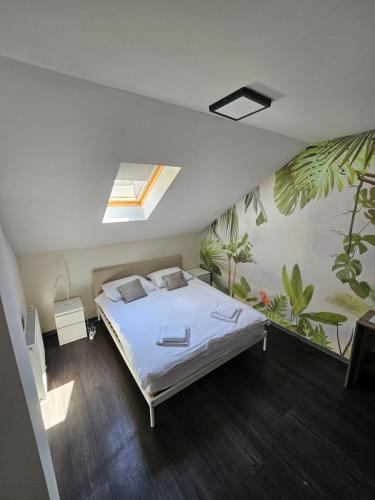 a bedroom with a bed and plants on the wall at KAPTOL Rooms in Zagreb