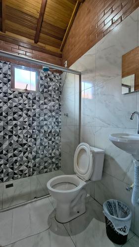 a bathroom with a toilet and a sink at Recanto Raios do Sol in Caldas