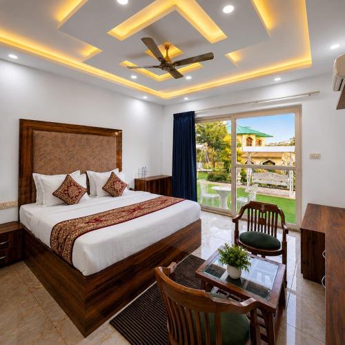 a bedroom with a bed and a table and a window at Heera Lodge Kasauli By Evening Sky Hotel in Kasauli