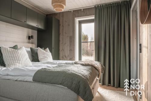 a bedroom with a large bed and a window at Black Grouse Lodge in Tällberg